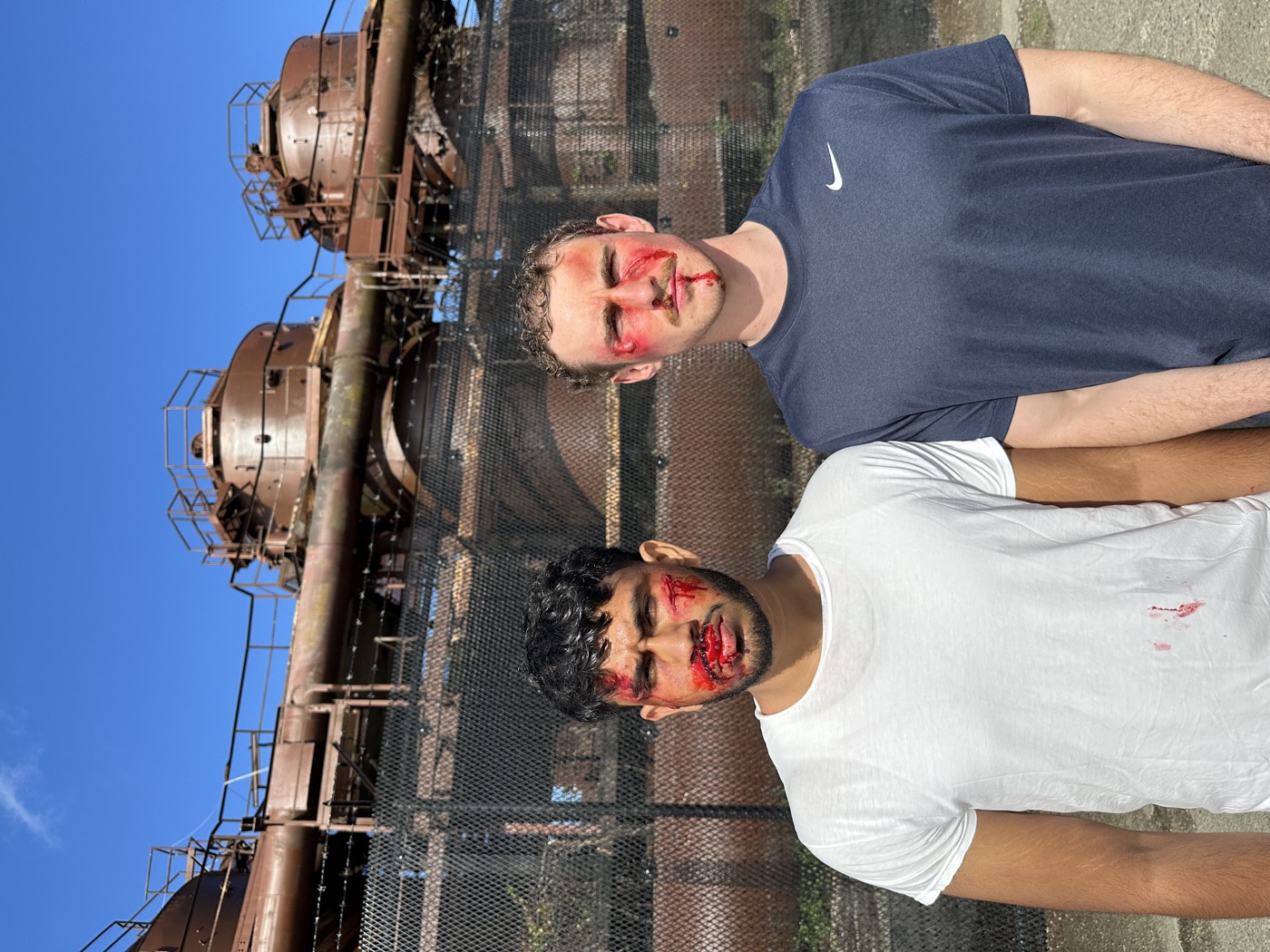 Sree and Jack Spangler standing side by side in bloodied fight makeup