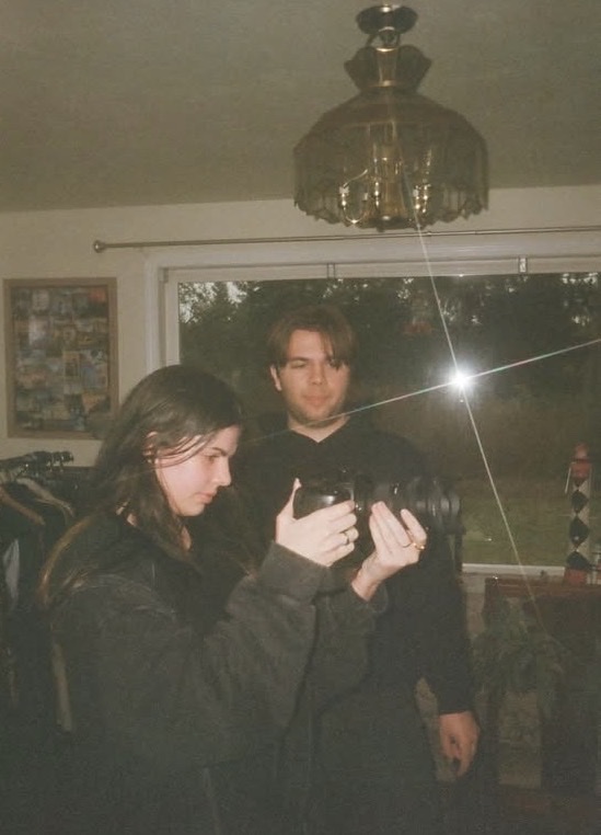Film photo of a crew member framing a shot with the camera on set
