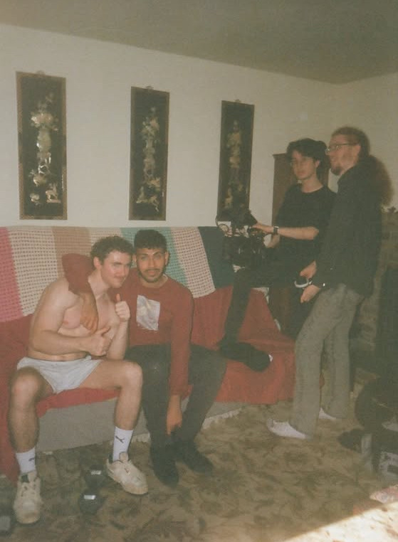 Film photo of Sree with his arm around Jack Spangler on set, crew behind them