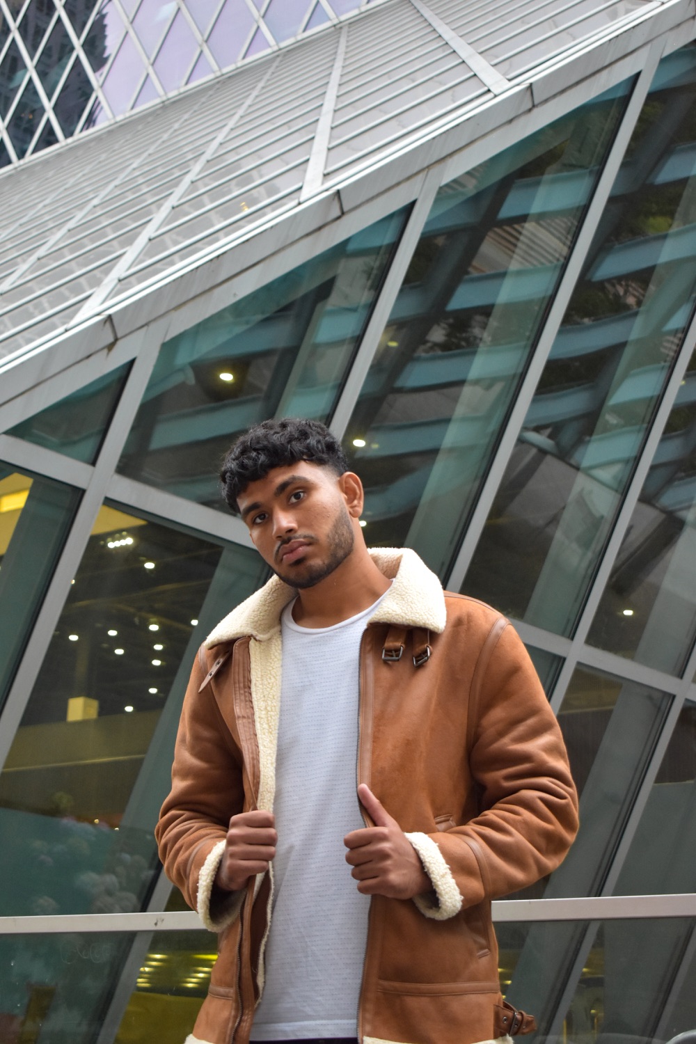 Sree in a shearling jacket, hands on the lapels, looking into the camera