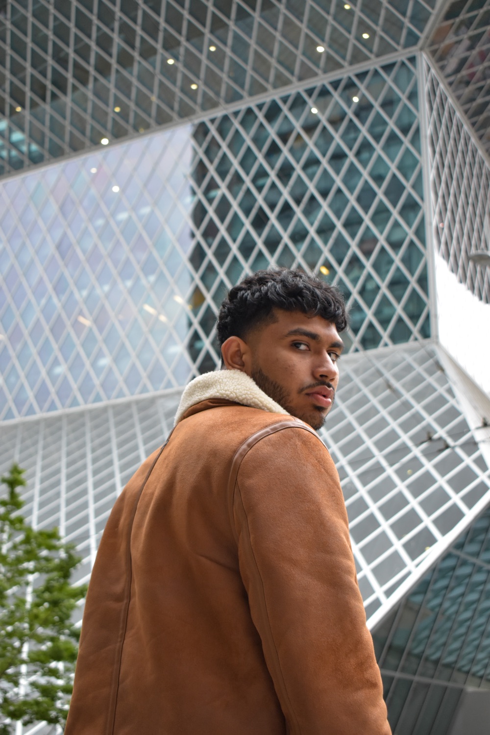 Sree looking back over his shoulder against the library's glass grid