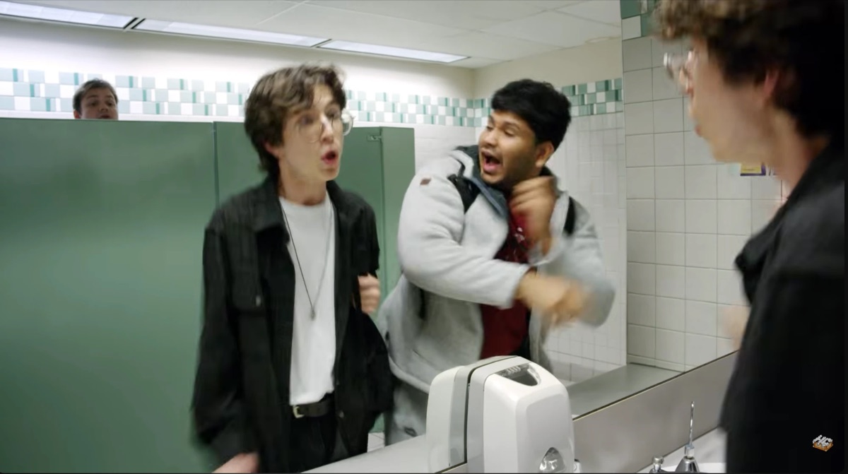 Sree as Chase mid-shout beside the bathroom mirror