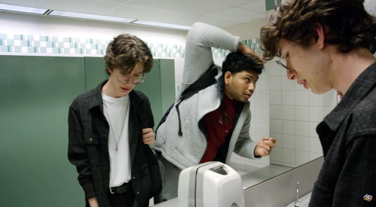 Sree as Chase fixing his hair in the mirror while his friend cringes