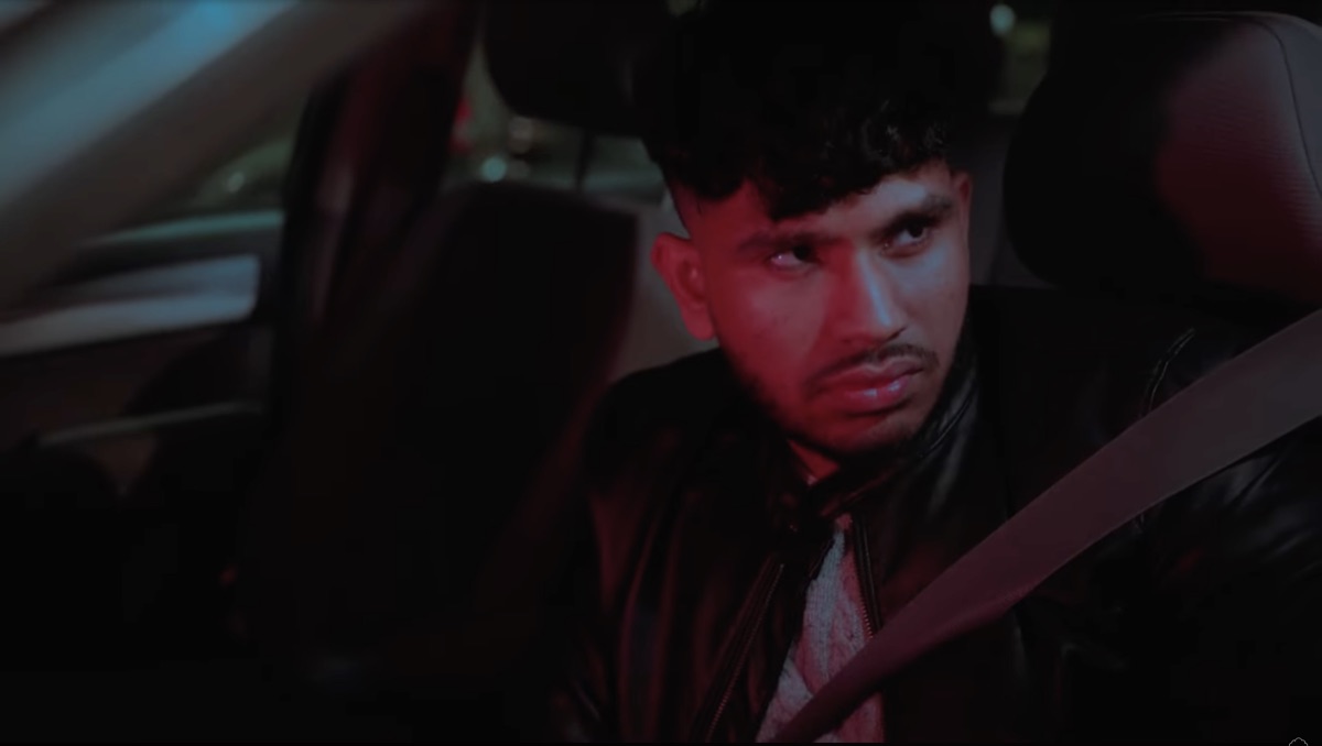 Sree as Sebastian in a car at night, lit red