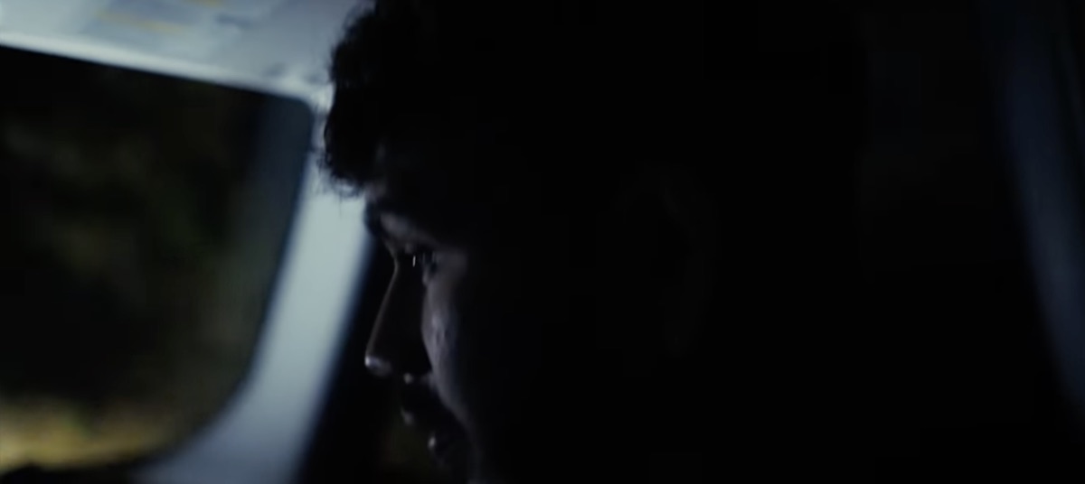 Sree as Ben in profile, lit by passing headlights
