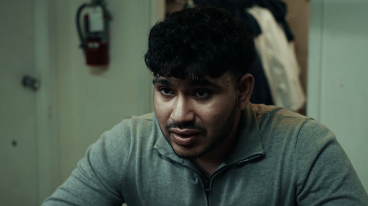 Sree as Sam in a break room, unimpressed