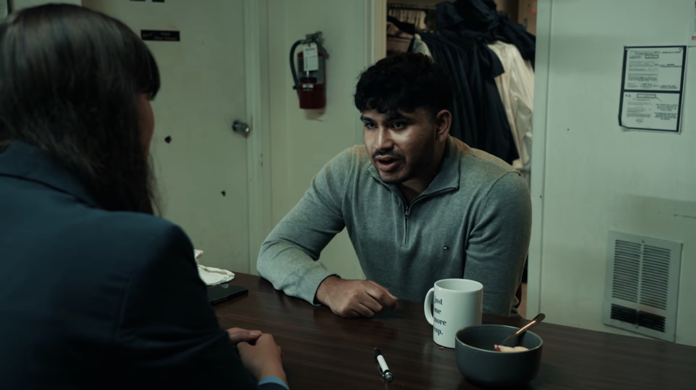 Sree as Sam arguing across a break room table